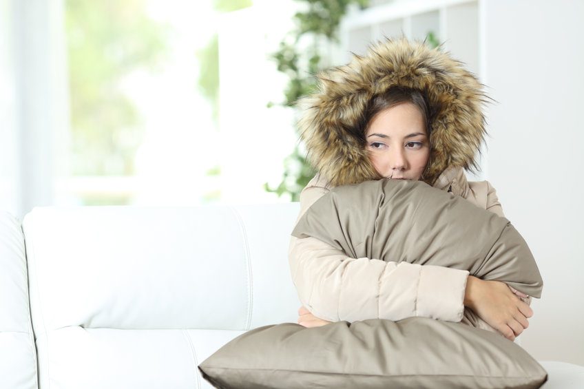 woman wearing jacket in home because furnace isn't working